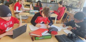 Group of Junior High students work at their tables.